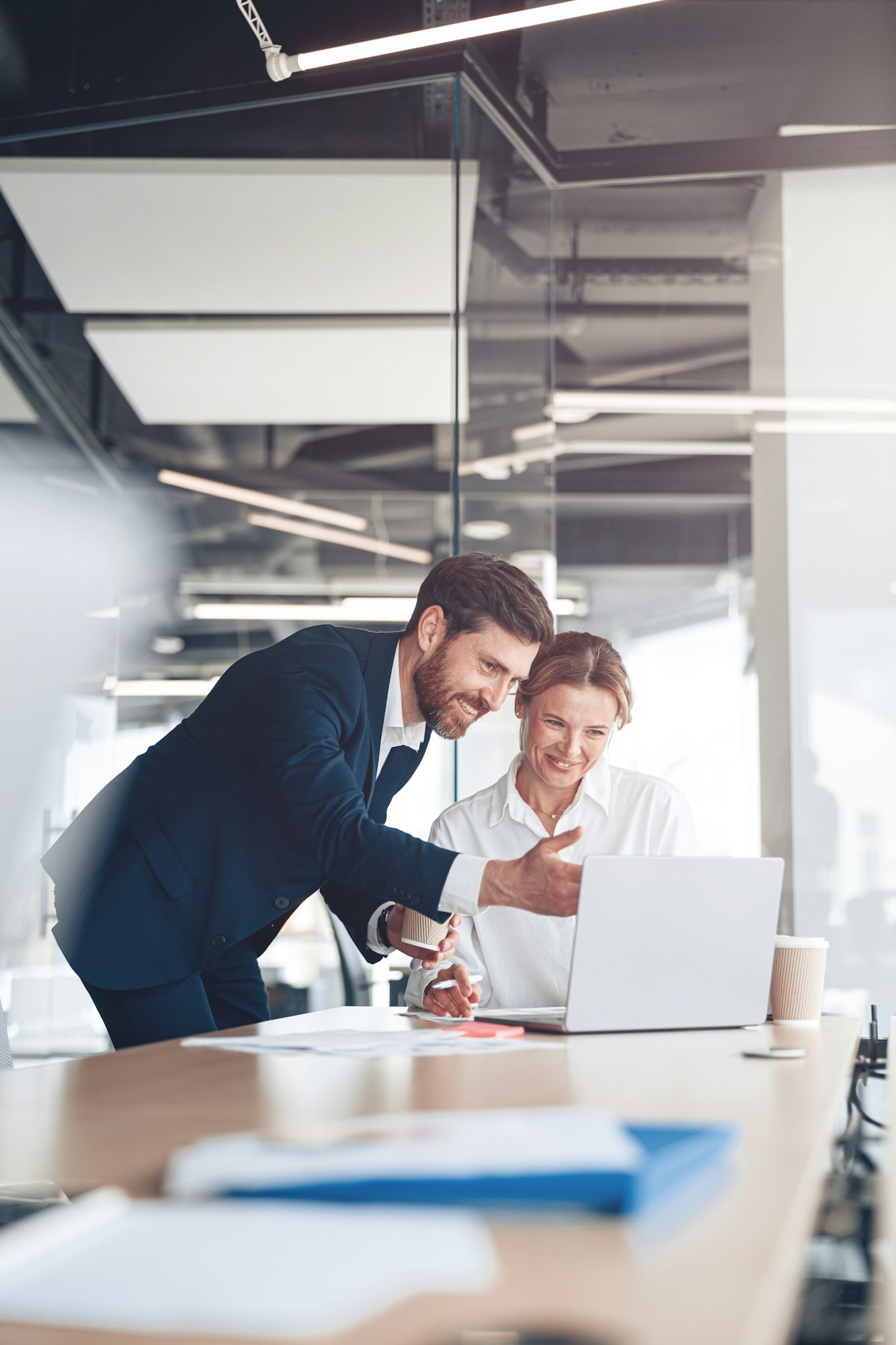 Happy employee showing presentation to mature female boss for discussing online project